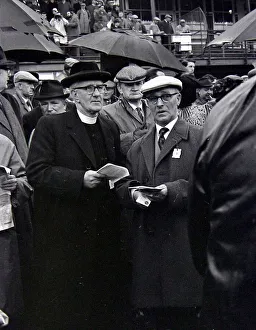 Vicar Prints: A priest holds his guide during a day out at the races in Cheltenham March 1963