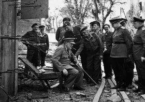 00723 Prints: Prime Minister Winston Churchill rests on one of the damaged chairs from the bunker in