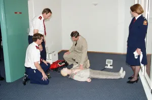 Prince Charles demonstrating resuscitation techniques on an inflatable doll at an