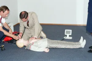 01507 Prints: Prince Charles demonstrating resuscitation techniques on an inflatable doll at an