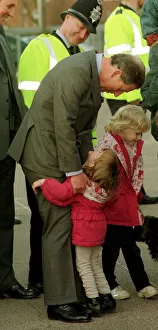 Prince Charles gets an unexpected hug from four year old Sarah Norris during a school