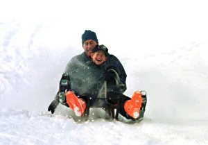 Prince Charles on a sledge with Prince Harry while on holiday in Klosters