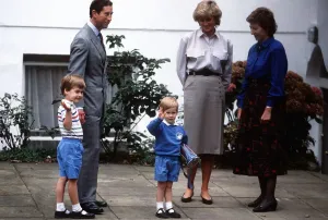 Prince Harry, wearing a blue sweatshirt shorts and Thomas the Tank Engine bag