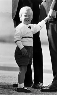 Images Dated 8th September 1984: Prince William grips the finger of father Prince Charles at Aberdeen airport