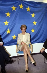 Princess Diana poses beneath the flag of the European Community in Brussels