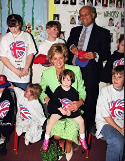 Princess Diana sitting with Caitlin Hines on her lap during a visit to a children
