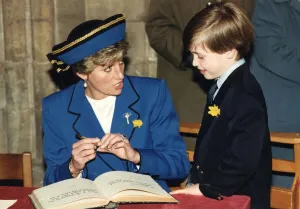 Princess Diana with her son Prince William signing their names in the visitors book of