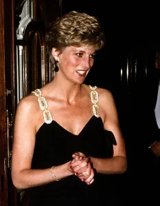 Princess Diana wearing a black low cut dress as she arrives at the London Coliseum