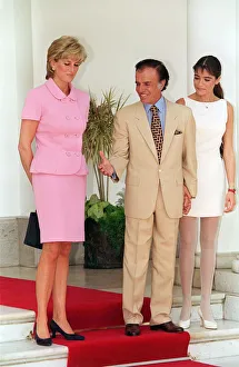 PRINCESS DIANA WEARING A PINK SUIT AND BLACK SHOES STANDING NEXT TO CARLOS MENEM