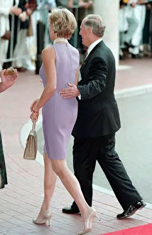 Princess Diana, wearing a purple dress is escorted to lunch by Australian dignitary Tom