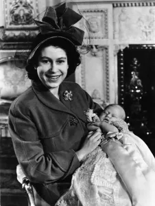 Princess Elizabeth holds her baby son Prince Charles in the drawing room at Buckingham