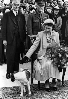 Princess Elizabeth II at Sark receiving a bouquet of flowers Dog at feet looking