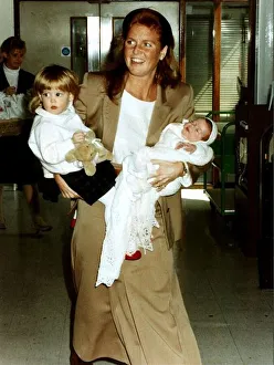 Princess Eugenie and Princess Beatrice being held by their mother the Duchess Of York