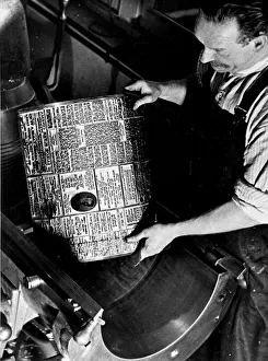 Printers Circa 1950 Printer places a hot metal plate on a printing press
