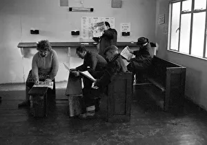Punters seated on church pews as they study the guide before placing a bet at Mac