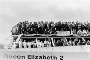 QE2 returns home to Southampton. Union Jacks are festooned on cars, draped on shoulders