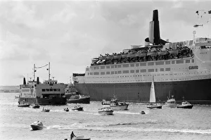 QE2 returns home to Southampton. Union Jacks are festooned on cars, draped on shoulders