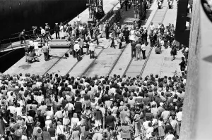 QE2 returns home to Southampton. Union Jacks are festooned on cars, draped on shoulders