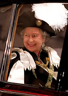 Queen Elizabeth 11 smiling from a car wearing cerimonial robes In Edinburgh at St Giles