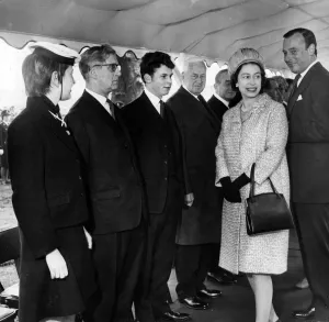 Queen Elizabeth II greets the cheers of the crowds at Worsley Bridge with a smile