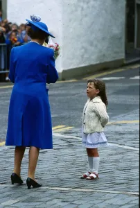 00189 Prints: Queen Elizabeth II July 1989 taking flowers from a little girl who is looking up At her