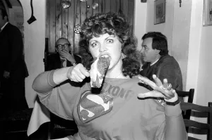 Queen: Kong: A woman sitting at a table with a large plate of food in a restaurant