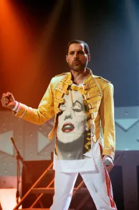 Queen rock group performing. Singer Freddie Mercury on stage