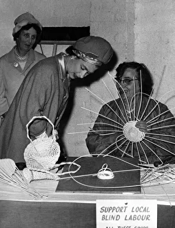 The Queen talks with Mrs Agnes Morris as she makes a basket at the Blind Institute stand