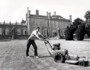 Racing driver Ayrton Senna, on a slow lap mowing the grass at Lotus team HQ