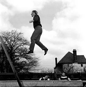 Racing driver Graham Hill at home with children 1968 on trampoline in his garden