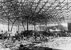 01449 Prints: RAF ground crew clear up wreckage inside a bomb shattered hangar at an airport near