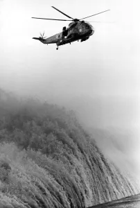 A RAF search and rescue Sea King helicopter from RAF Boulmer hovers above huge waves