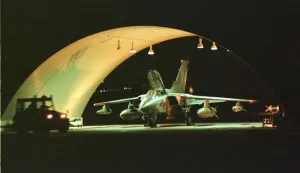 Illuminated Prints: An RAF Tornado GR1 jet being prepared for battle in the hangar at Ali Al Salem Air Base