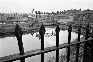 Bridges Prints: Railings, blackened by 150 years of industrial smoke separate the weed grown banks of