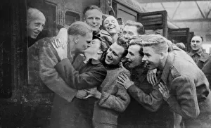 Kiss Prints: Railway Guard Mrs Connelly gives a big kiss to British troops arriving home at Glasgow