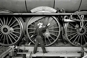 Railway worker shows the scale of the wheels on the Flying Scotsman steam train