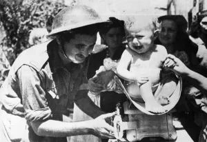 Italy Prints: RAMC man fins a new kind of patient. Weighing a Sicilian baby