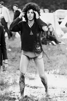 Afro Prints: Reading Pop Festival. A festival goer walking bare foot through the mud