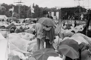 Hippy Prints: Reading Pop Festival. Young couple stand up to get a better view of the main stage