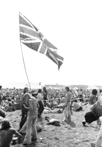 Hippy Prints: Reading Pop Festival. Young festival goers carrying the Union Jack flag as they