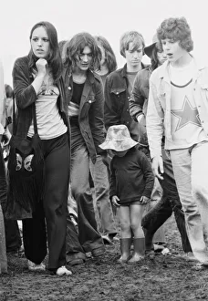 Men And Women Prints: Reading Pop Festival. Young festival goers with small child wearing her wellington