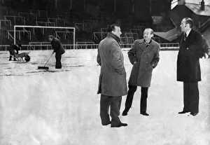 Winter Prints: Referee Roy Capey weighs up the snow covered Anfield pitch with Liverpool manager Bob