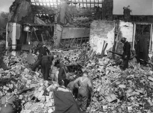 Rescue workers search rubble for survivors after a parachute mine detonated on Bean