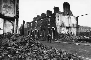 Demolition Prints: A resident walks along a road full of part demolished houses in the Openshaw area of