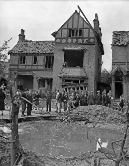 Residents gather around a water filled crater outside a house in Wood End Road, Erdington