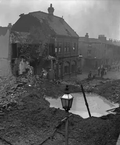 Residents gather around a water filled crater outside a public house in Newtown Row