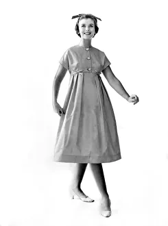Reveille Fashions 1958: Ann Cave modeling a button summer dress. October 1958 P006896