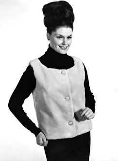 Hair Styles Prints: Reveille Fashions 1964: Gloria James modeling a fur waistcoat. January 1964 P007613