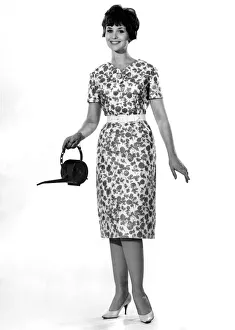 Summer Dress Prints: Reveille Fashions: Ann Cave wearing floral summer dress and holding a watering can
