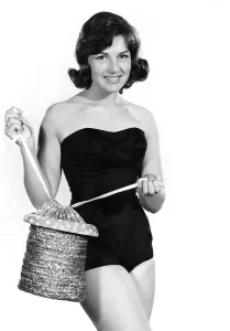 00053 Prints: Reveille Fashions: Diana Lovell wearing a one piece swimming costume holding a rope beach